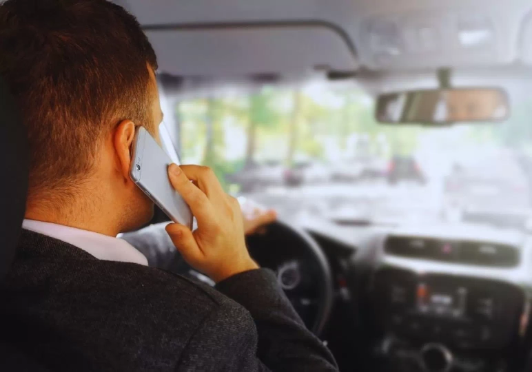 Mężczyzna używa telefonu za kierownicą
